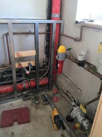 Badezimmer-Rohrinstallation im Rohbau mit roten Leitungen