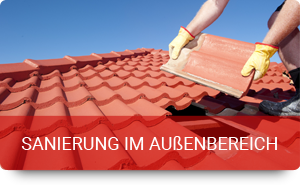 Handwerker legt rote Dachziegel beim Dachsanierungs-Projekt